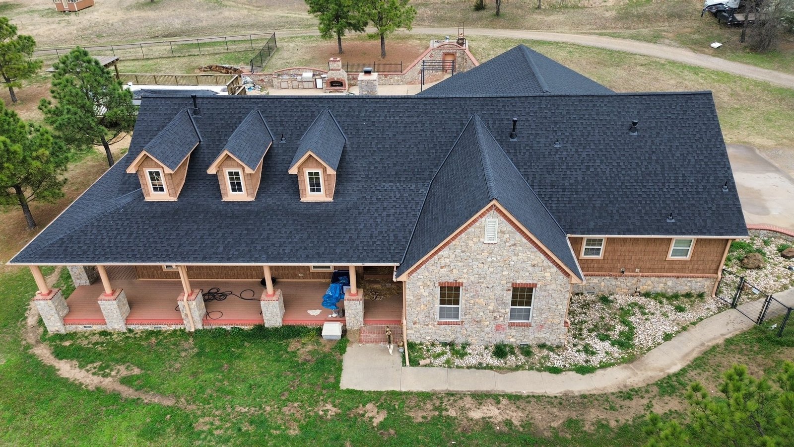 Full roof replacement with Owens Corning Duration Storm shingles and ridge ventilation on stone and cedar home, South 4160 Road, Claremore, OK — Aces Roofing and Exterior Solutions