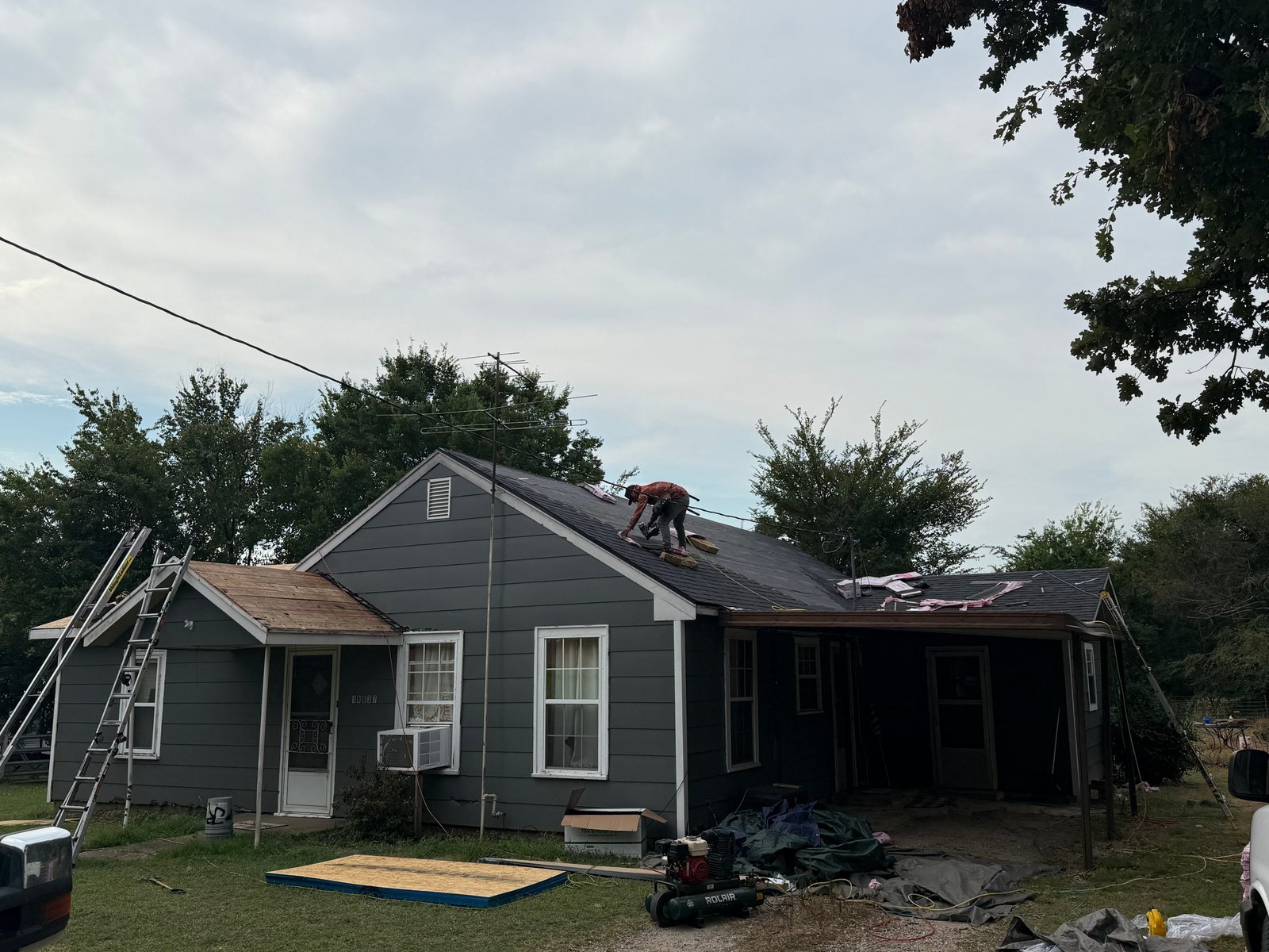Aces Roofing and Exterior Solutions crew repairing shingles on a steep residential roof located at 36° 20' 29.95