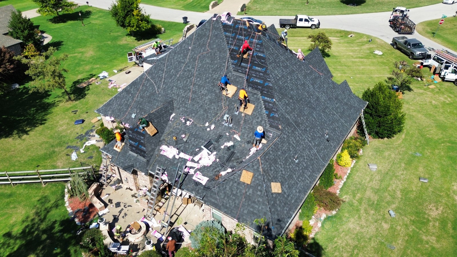 Professional roofer inspecting damaged roof shingles for repair assessment
